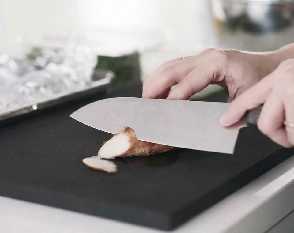 Tiras de pechuga de pollo cocida dispuestas sobre una tabla de cortar.
