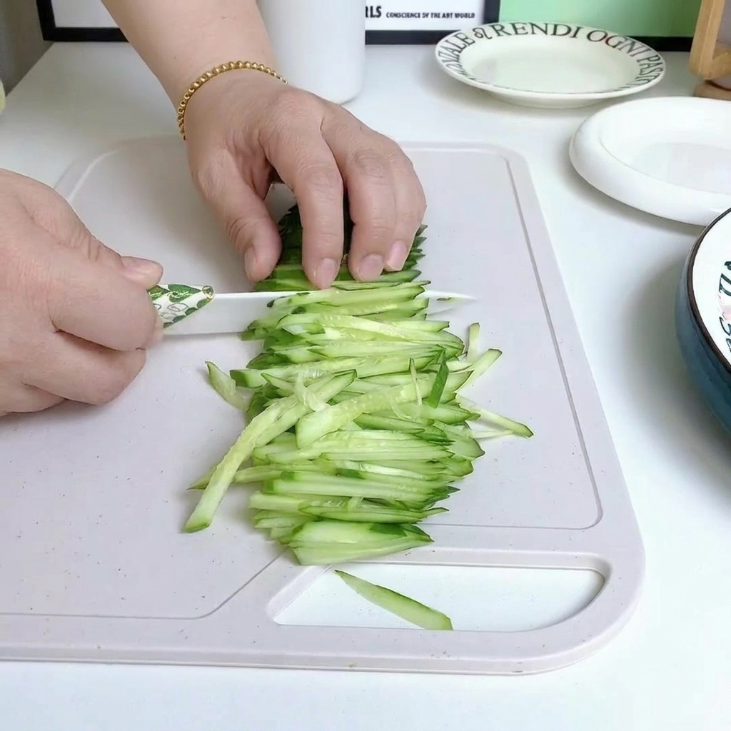 Pepino fresco cortado en tiras finas sobre una tabla de cortar.