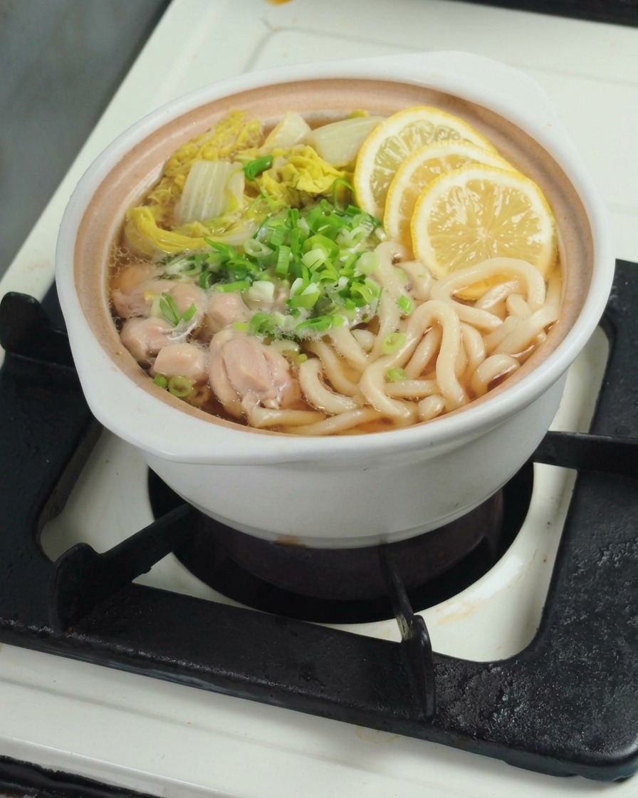 Exprimir un trozo de limón fresco directamente en la cazuela con udon y bok choy.