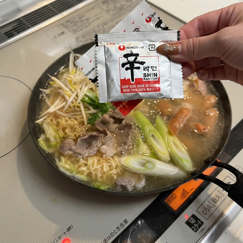 Añadiendo el sobre de sazonador de fideos a la sartén.