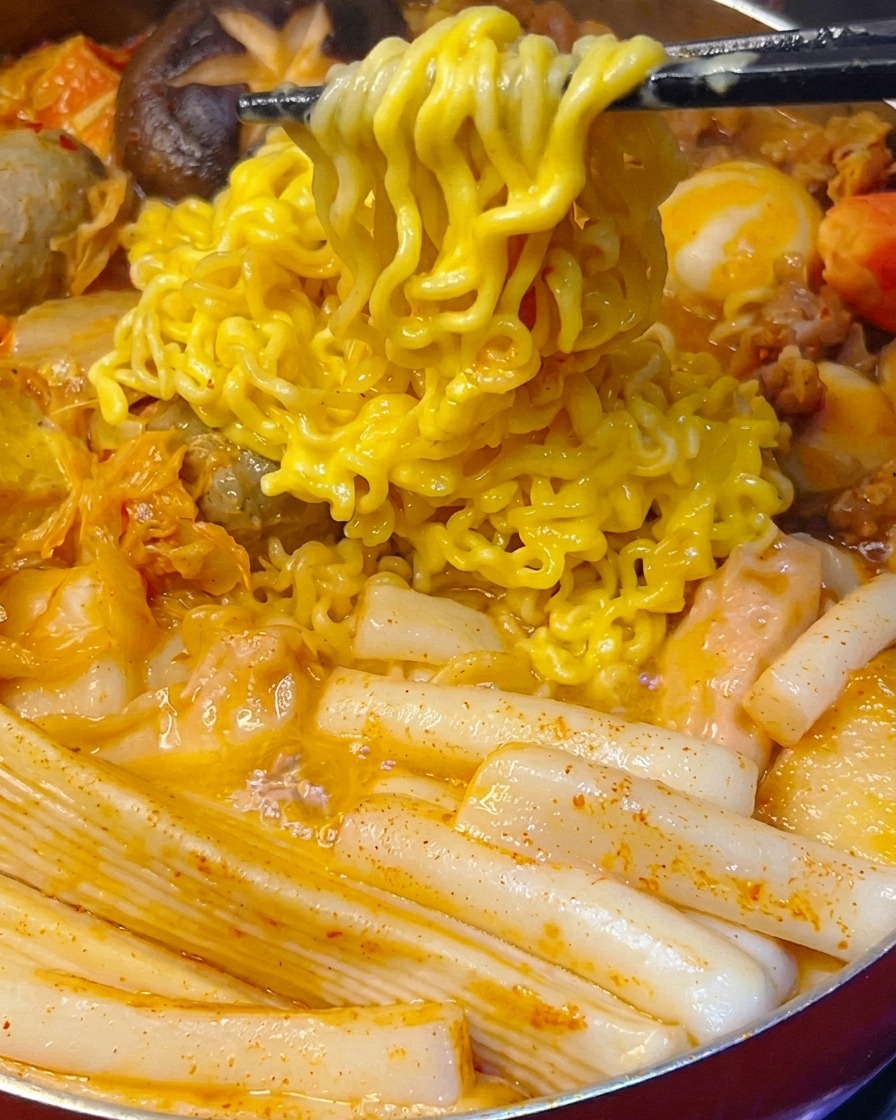 Rodajas de cebolla morada cocinándose en una sartén, volviéndose translúcidas y suaves.