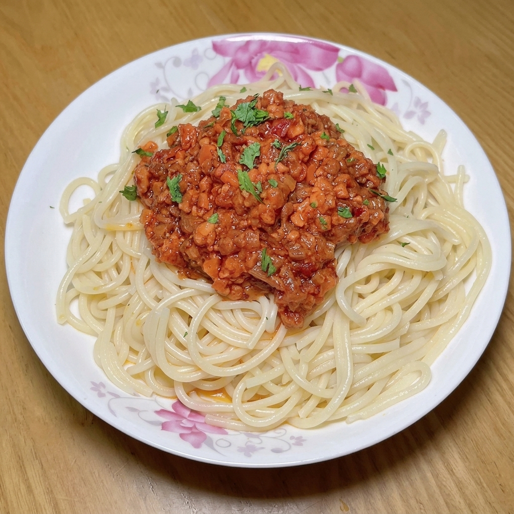 Tomates frescos picados siendo añadidos a una sartén con la carne, las verduras y la pasta de tomate.