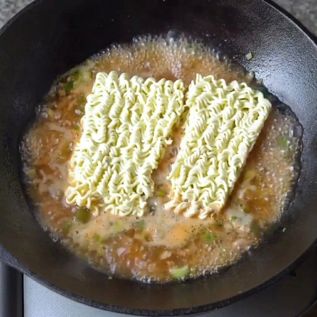 Bloques de fideos de ramen reposando en el caldo hirviendo.