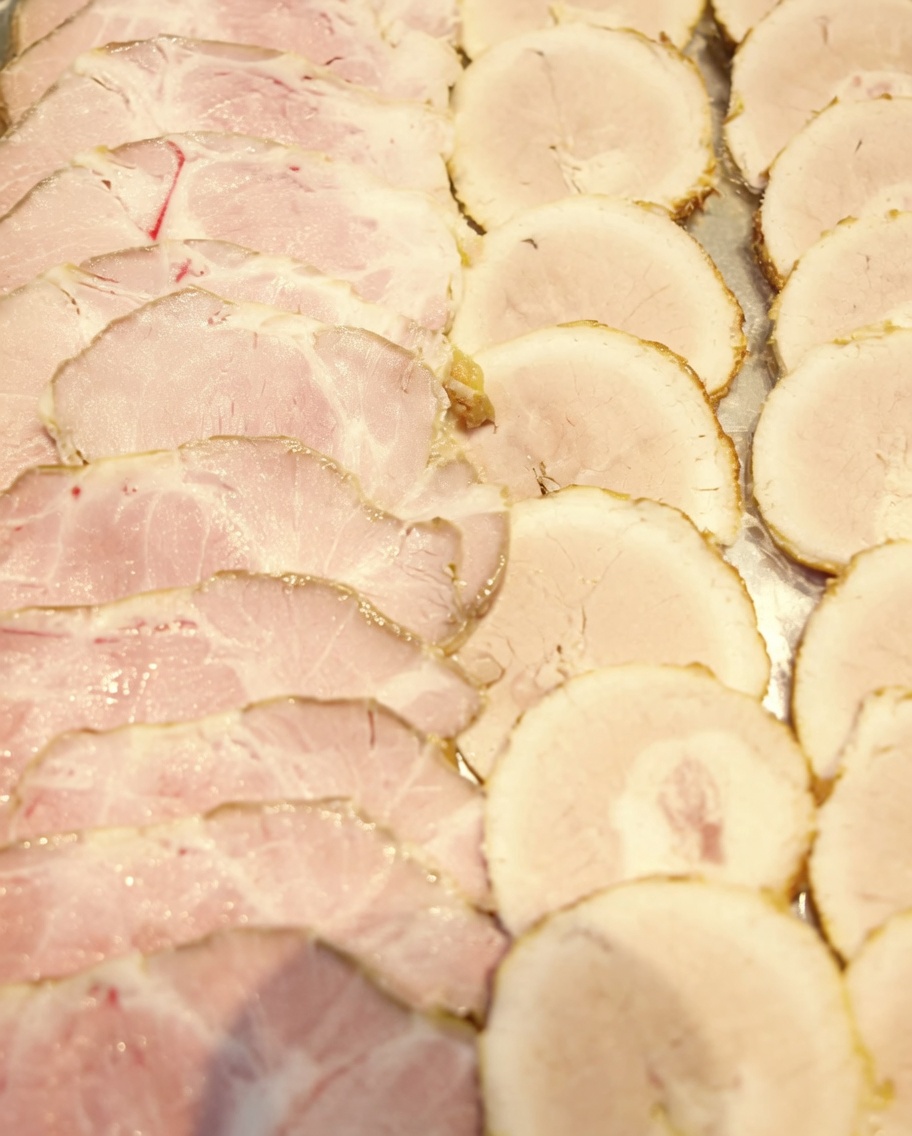 Rodajas finas de cerdo chashu dispuestas en una bandeja, listas para servir.