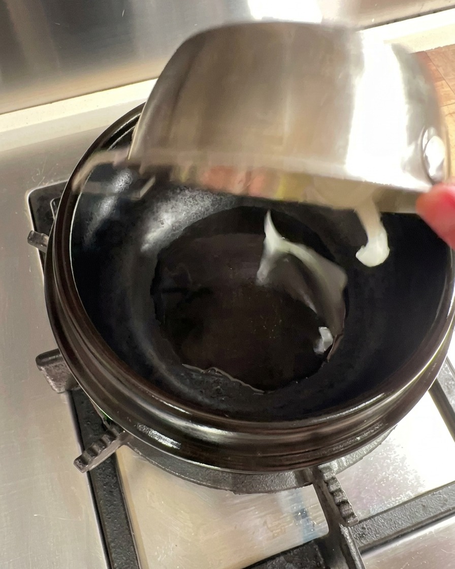 Rodajas de cebolla sofritas en una olla de barro precalentada con aceite.