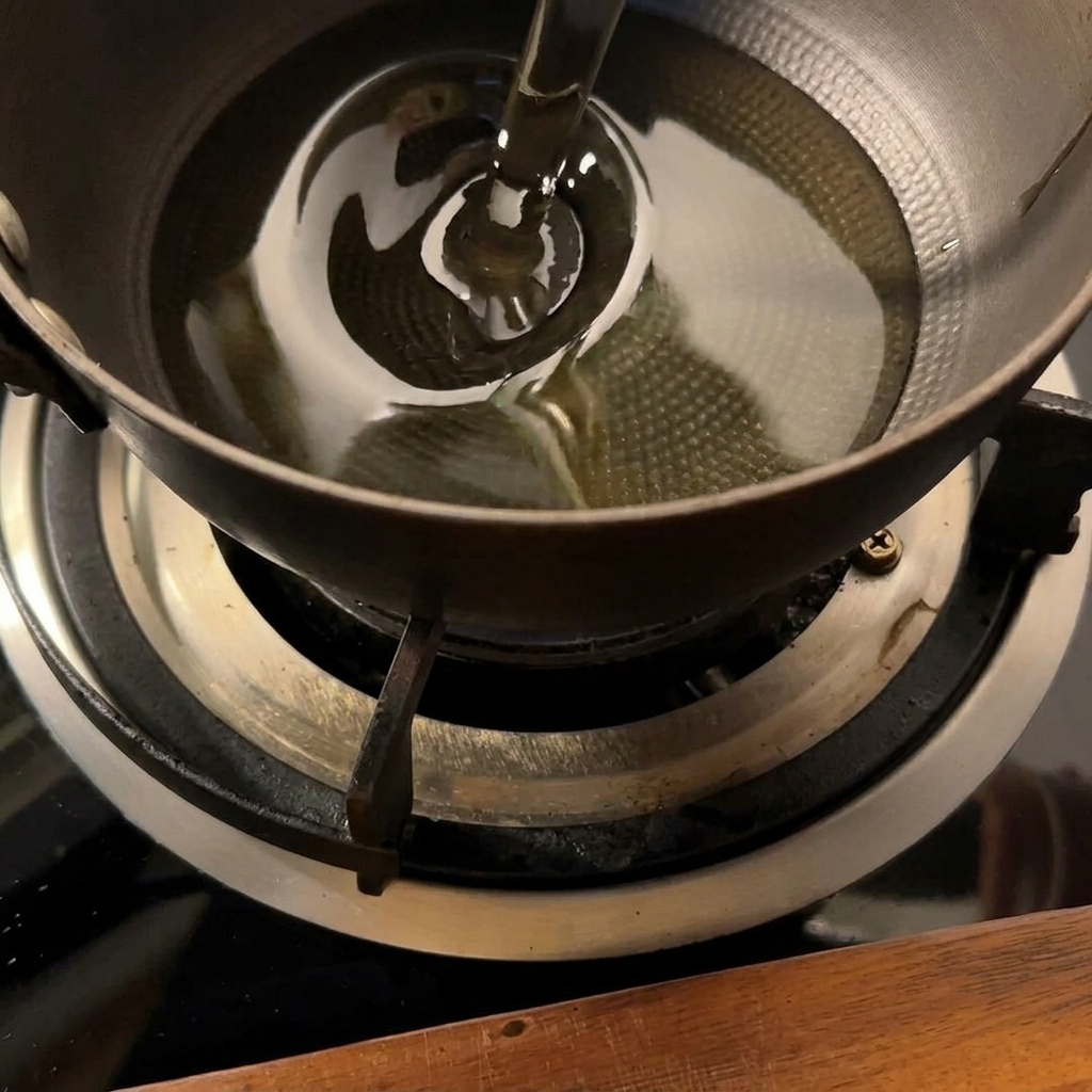 Papas friéndose en una pequeña olla de aceite caliente hasta que estén doradas.
