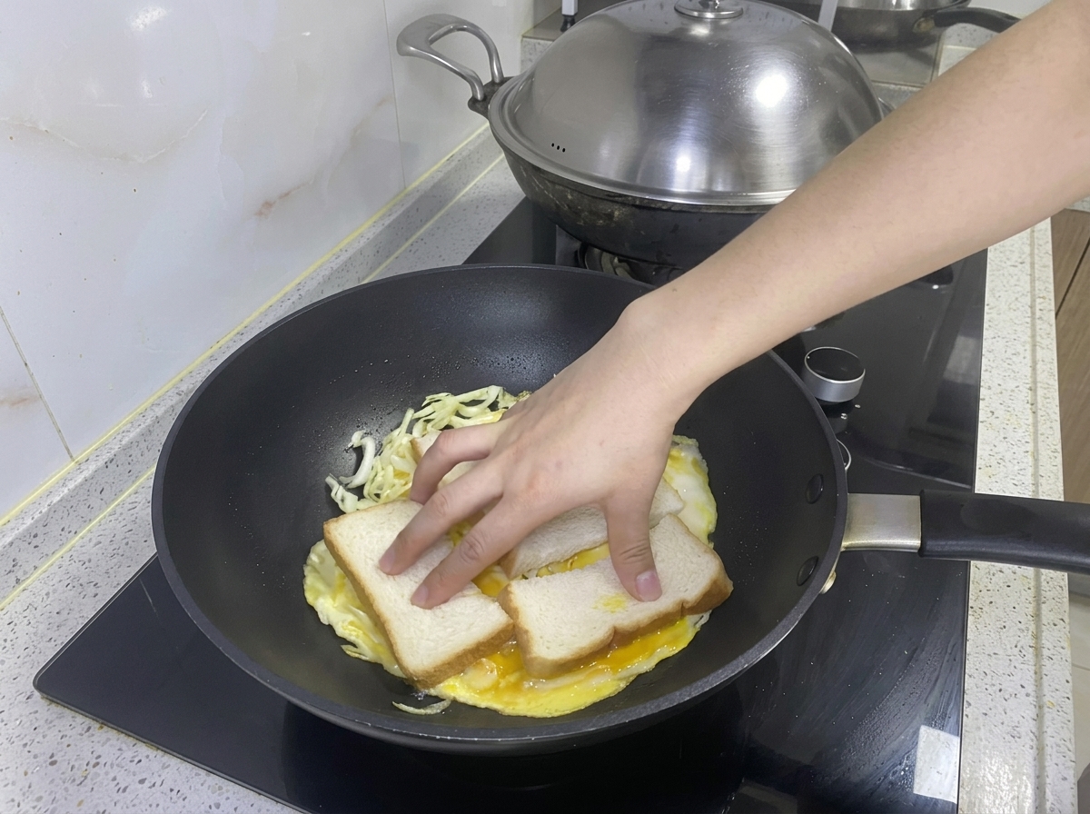 Dos rebanadas de pan colocadas sobre la tortilla de huevo y repollo en la sartén.