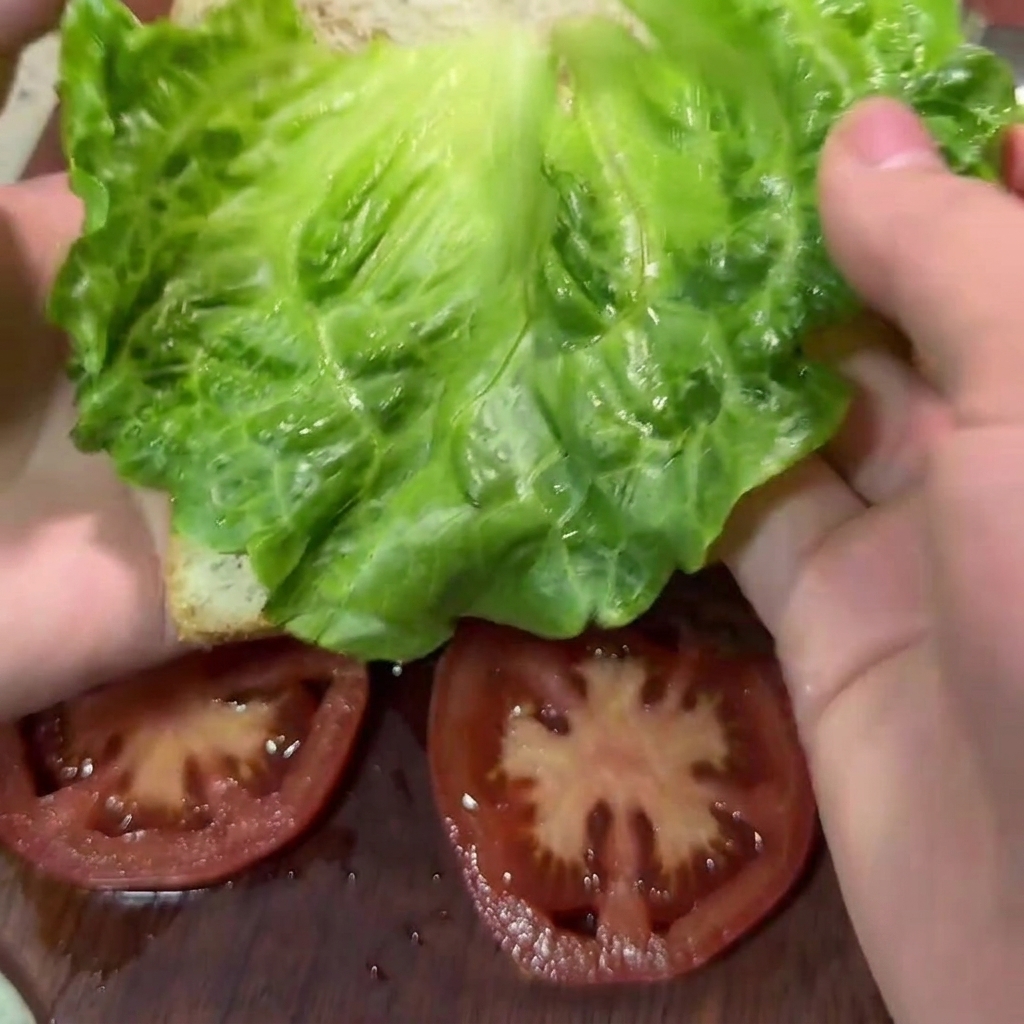 Una cuchara de madera mezclando la carne picada con el brócoli y la zanahoria en un bol blanco grande.