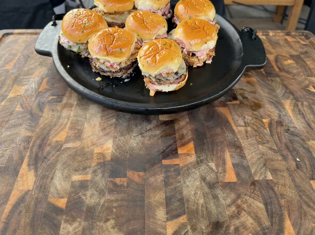 Hamburguesas de pavo dorándose en una plancha caliente, mostrando bordes dorados.