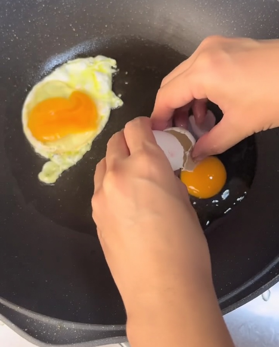Huevos friéndose en una sartén con aceite caliente.