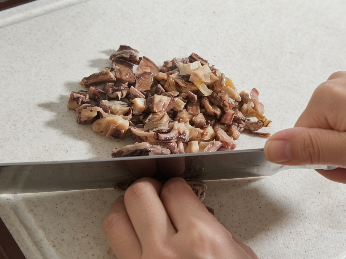 Manos usando un cuchillo grande para picar hongos shiitake rehidratados y trozos de pulpo en una tabla de cortar.