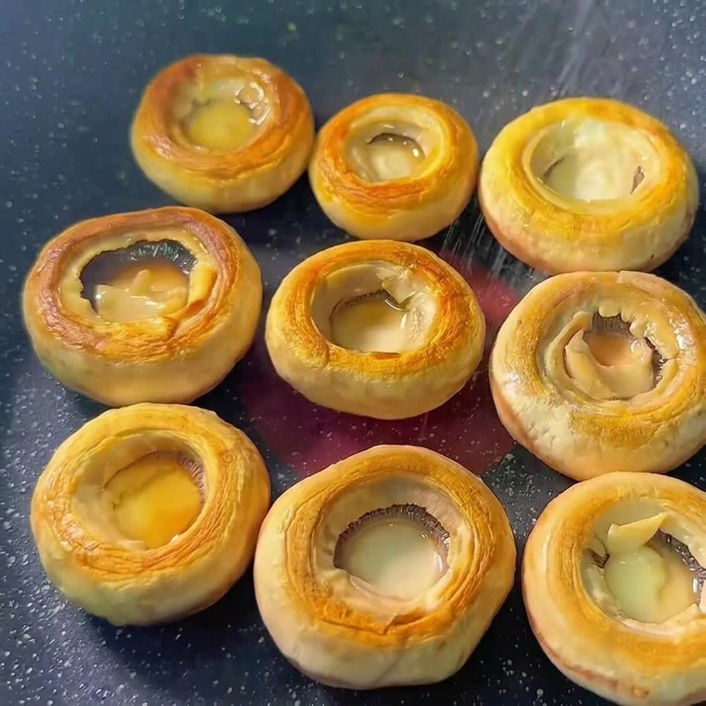 Sombreros de champiñón en una sartén sazonados con sal y pimienta.