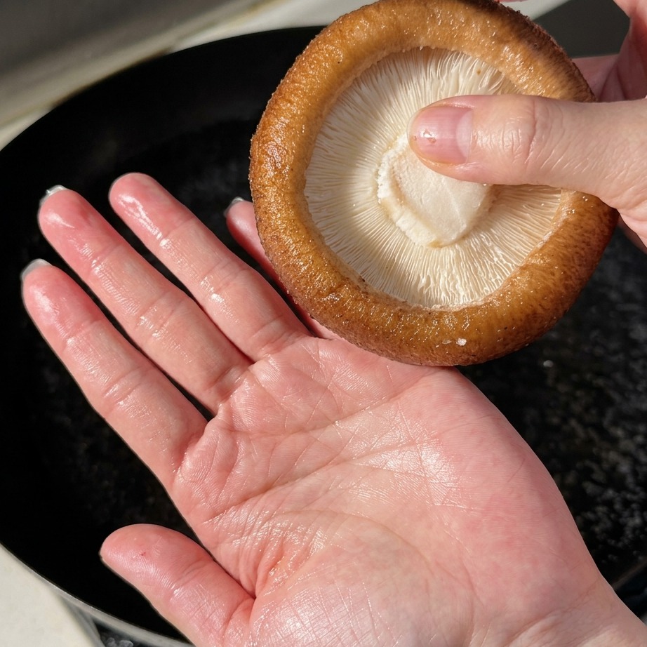 Champiñones shiitake grandes escaldándose en agua hirviendo.