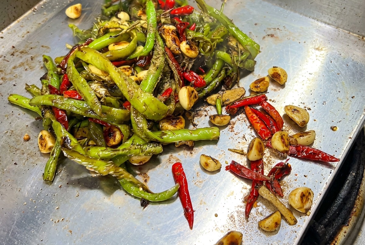 Ingredientes siendo mezclados con una espátula en la plancha caliente.
