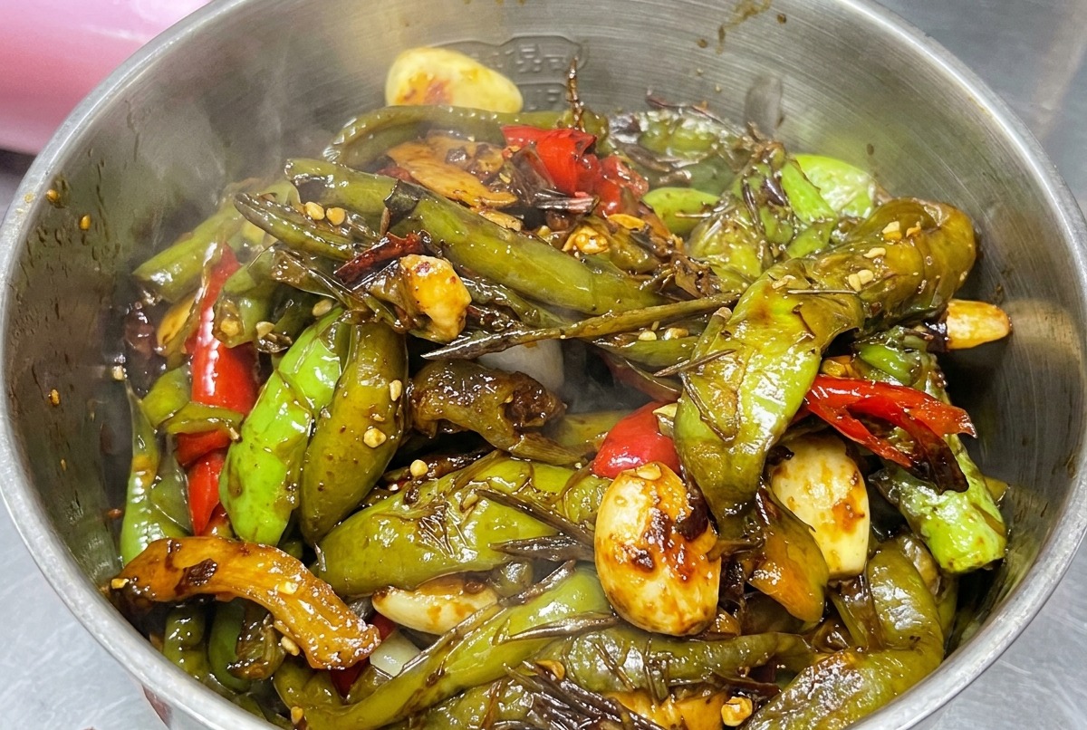 Mezcla de chiles cocinados siendo colocada en una licuadora.