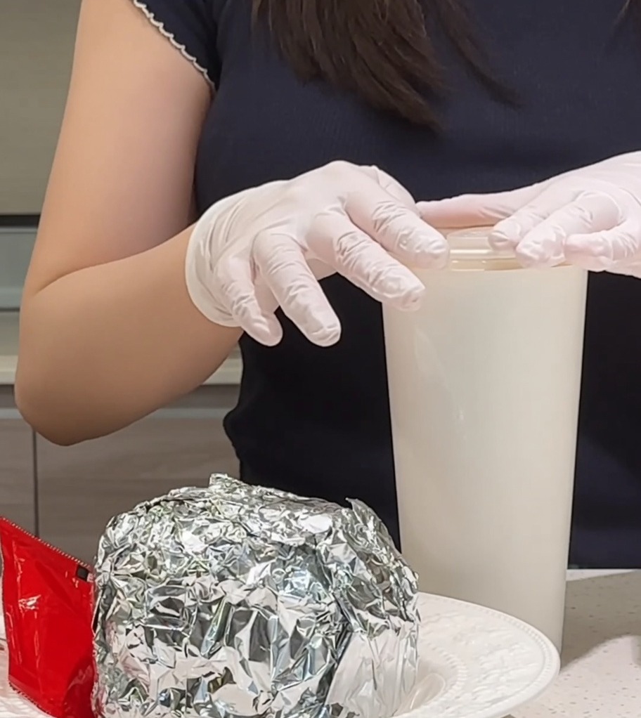 Un huevo frito recién hecho colocándose sobre una pila de bacon crujiente y carne jugosa.