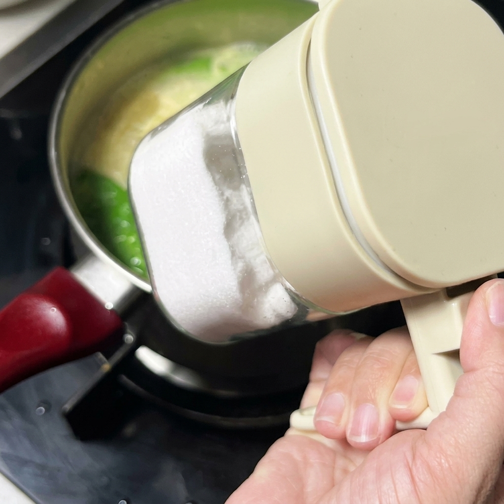 Sal añadiéndose a la sopa desde un recipiente de plástico transparente para condimentos.