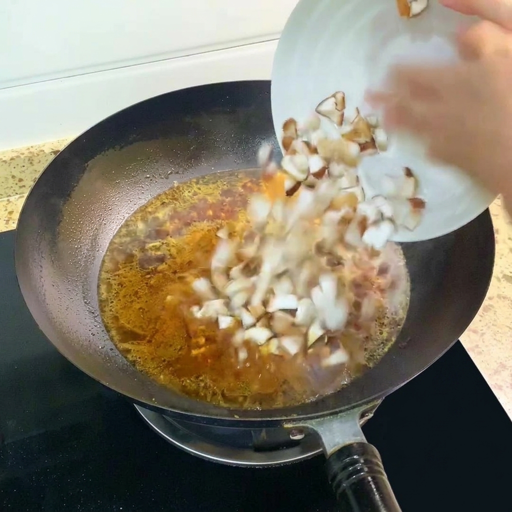 Setas shiitake cortadas en cubitos siendo añadidas a la sopa hirviendo en el wok.
