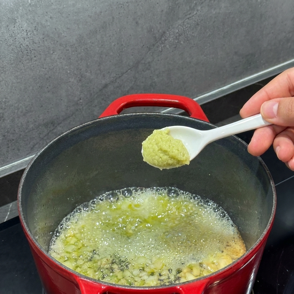 Harina siendo batida en la mantequilla derretida dentro de una olla.