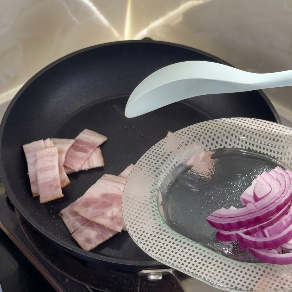 Trozos de bacon crudo chisporroteando en una sartén antiadherente caliente.