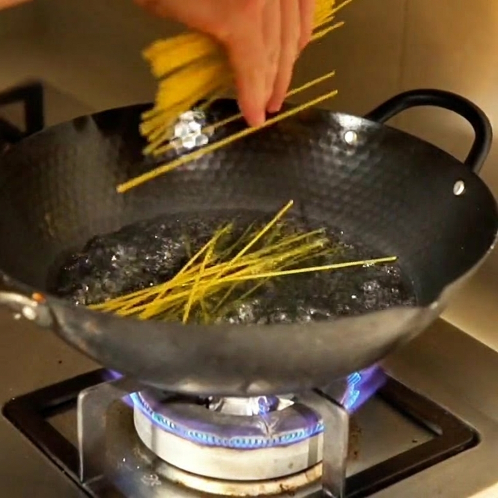 Fideos de maíz sumergiéndose en una olla con agua hirviendo.