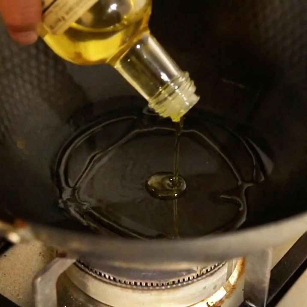 Ajo y chile en rodajas sofriéndose en una sartén con aceite de oliva caliente.