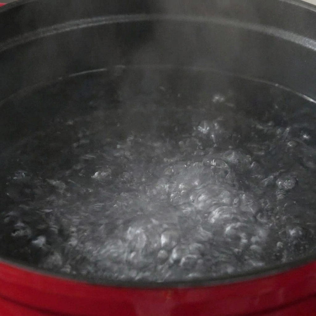 Pasta sumergida en una olla grande con agua hirviendo a borbotones.