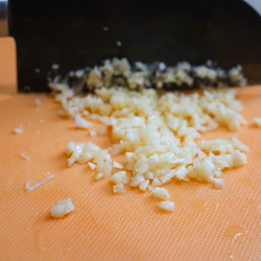 Montones de queso parmesano recién rallado descansando sobre una tabla de cortar.