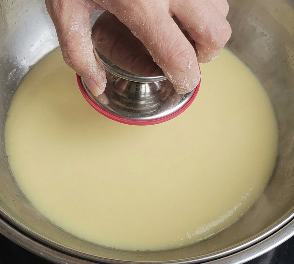 Brotes de bambú rehidratados siendo cortados en trozos pequeños sobre una tabla.