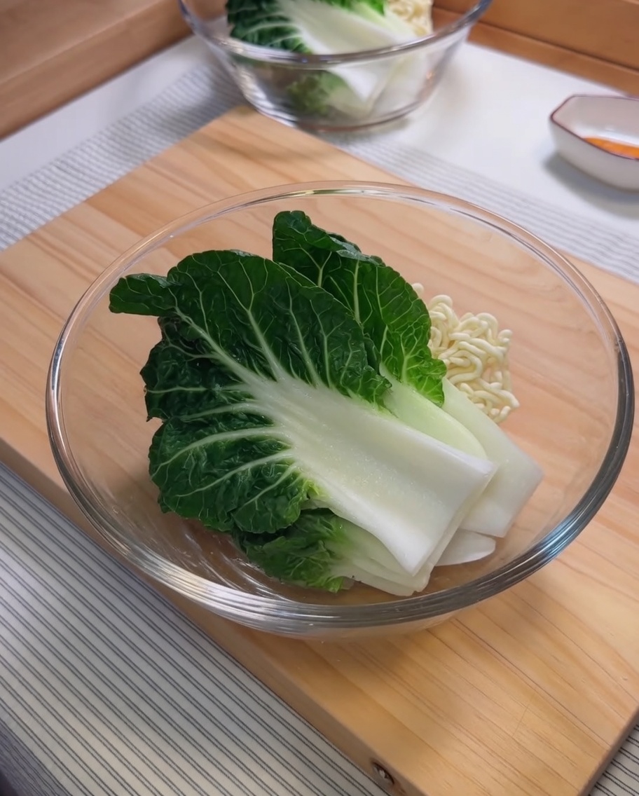 Ingredientes para la salsa de sésamo, incluyendo pasta de sésamo y aceite de chile, mezclándose en un bol de vidrio.