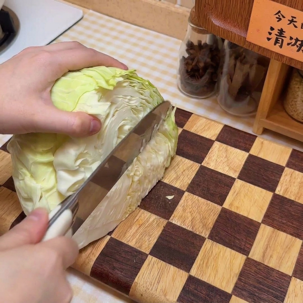 Una cabeza de repollo siendo rebanada sobre una tabla de madera a cuadros.