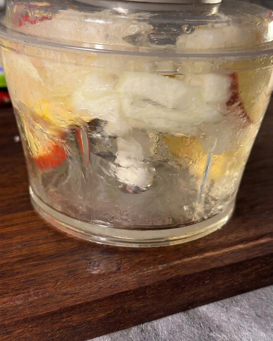 Mezcla suave de manzana, cebolla, ajo y jengibre dentro de una batidora.