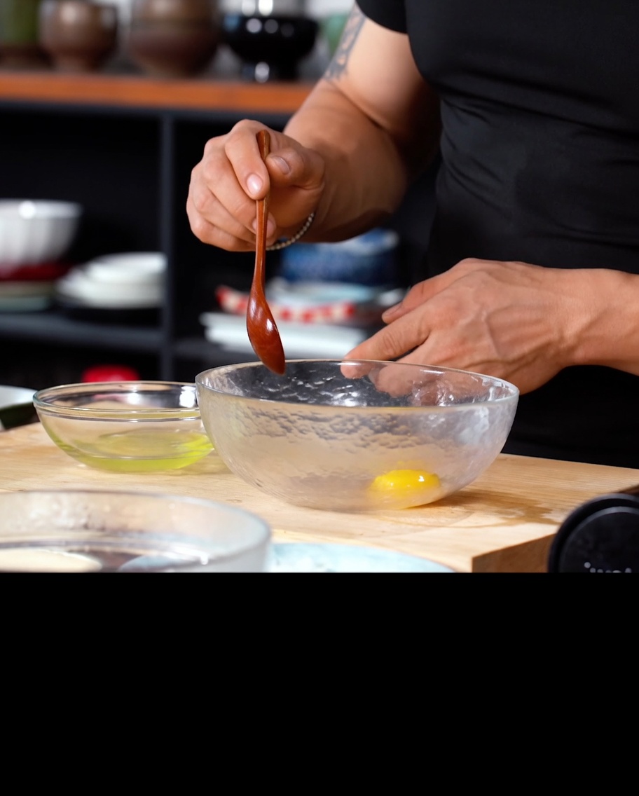 Una yema de huevo y agua fría en un tazón de vidrio, listos para batir con la harina para tempura.