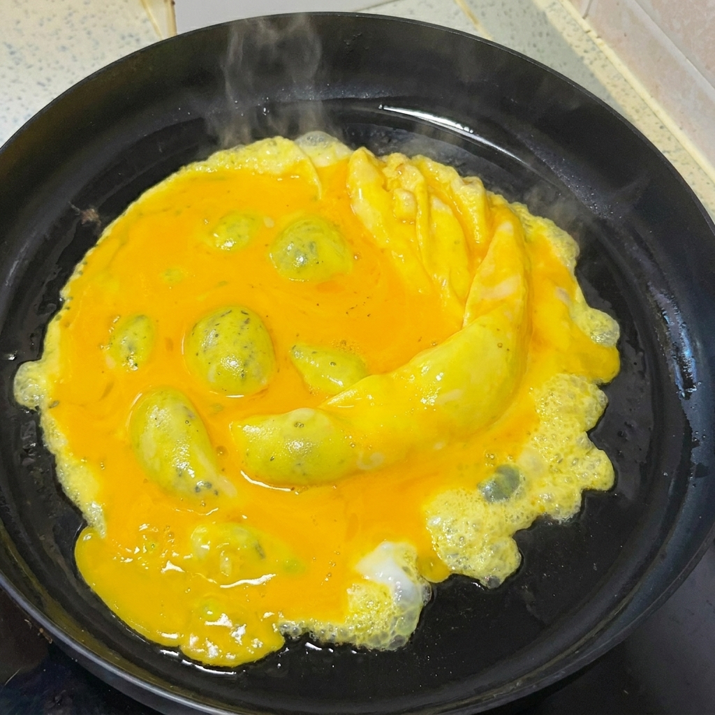 Huevos siendo revueltos suavemente en una sartén con una espátula de madera.
