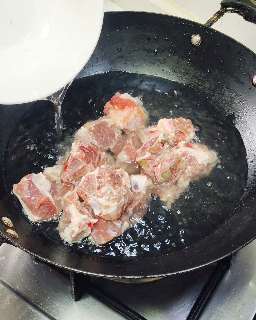 Un trozo de anguila a la parrilla pre-empacada siendo colocada en una sartén caliente.
