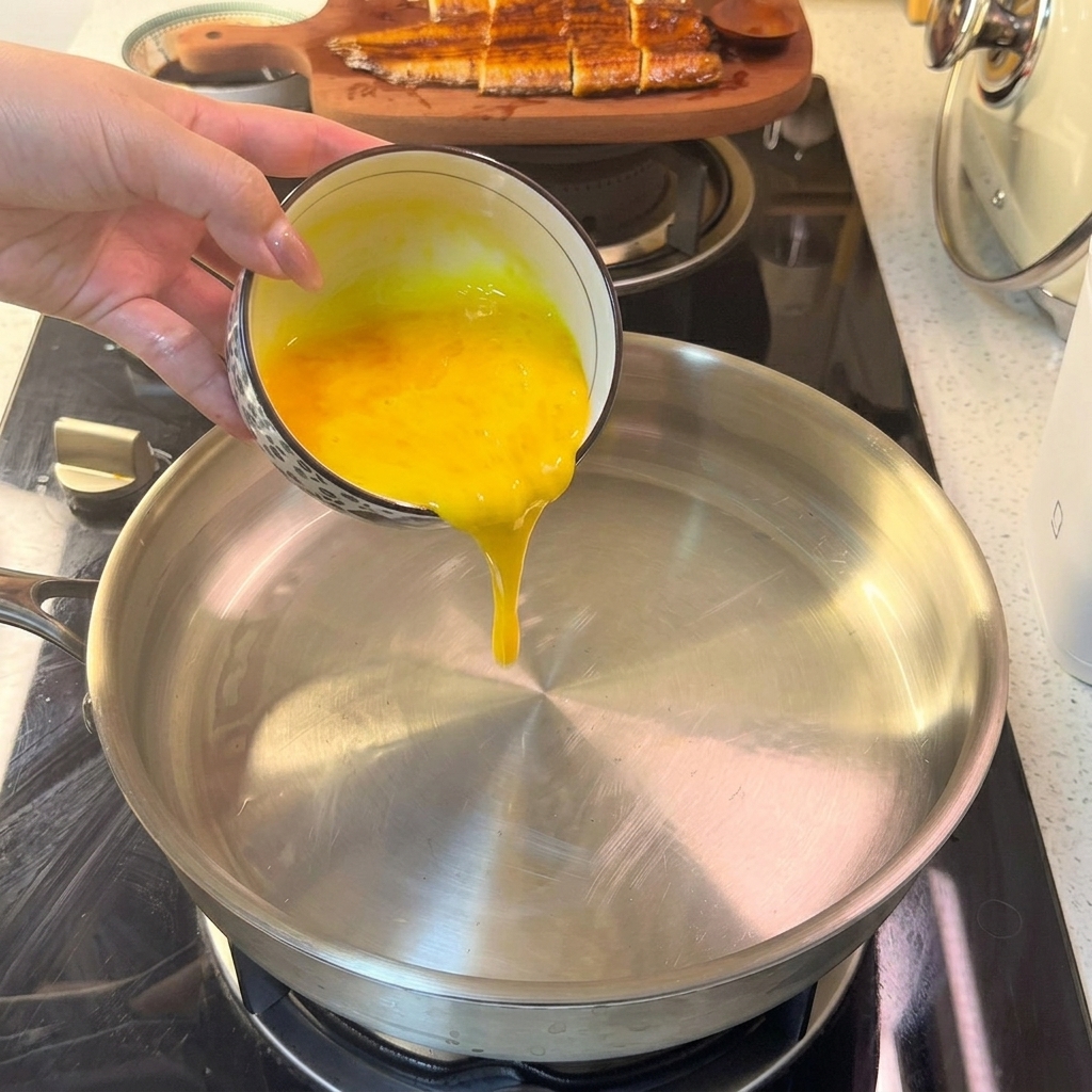 Mezcla de huevo líquido cayendo en una sartén caliente, comenzando a cuajar en una capa fina.