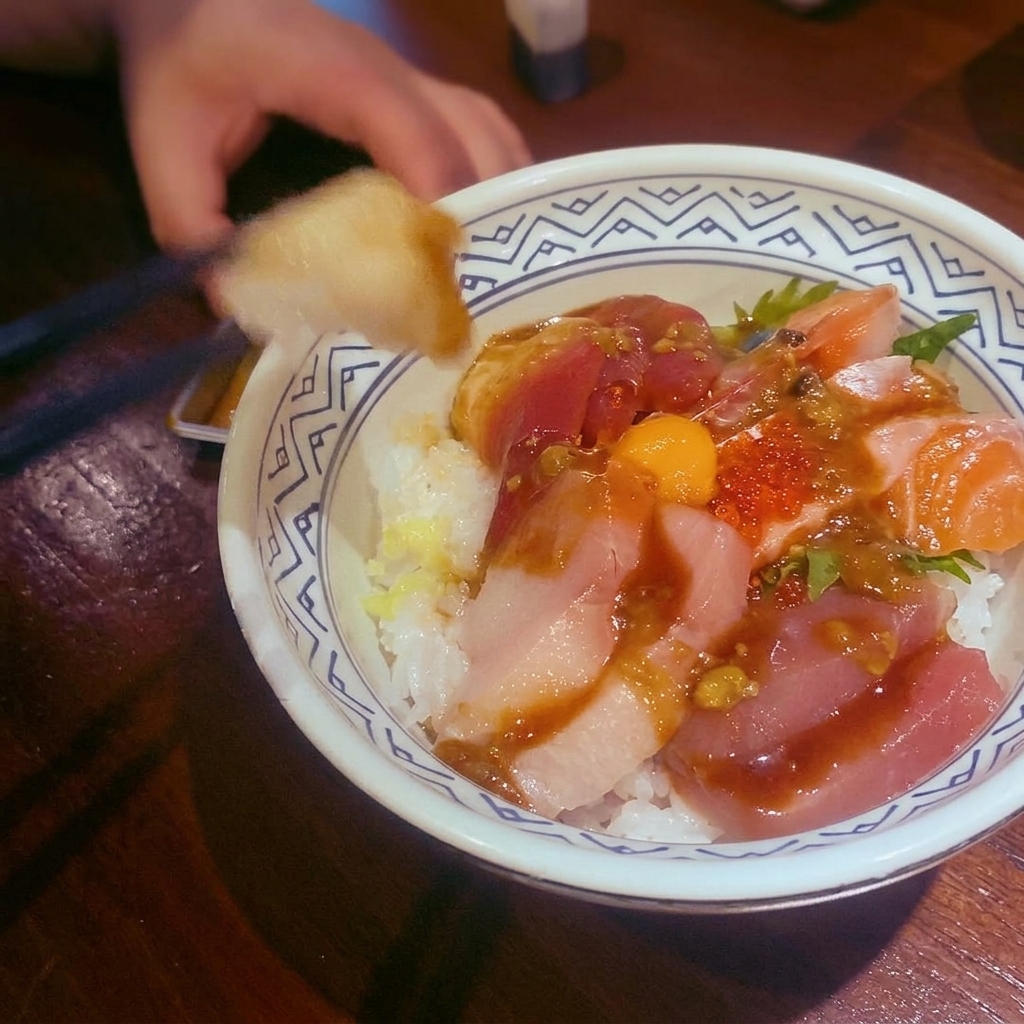 Un tazón de salsa de curry rojo servido sobre proteína y decorado con hojas de lima.
