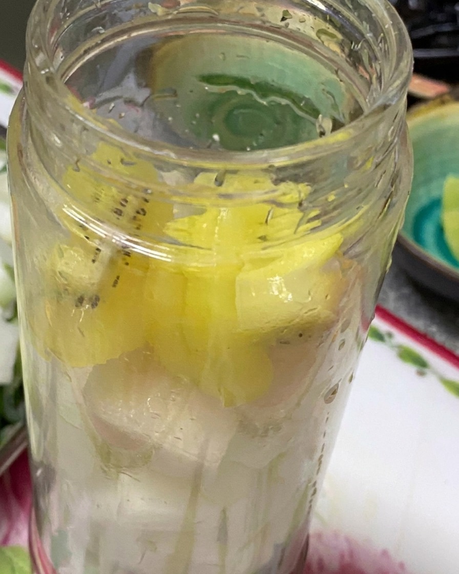 Trozos de cebolla, cebolleta, kiwi, ajo y pera dentro de una licuadora listos para hacer puré.