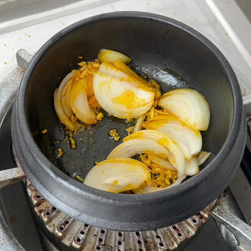 Porciones generosas de kimchi picado vibrante y rodajas de pimiento rojo siendo mezcladas en la olla.