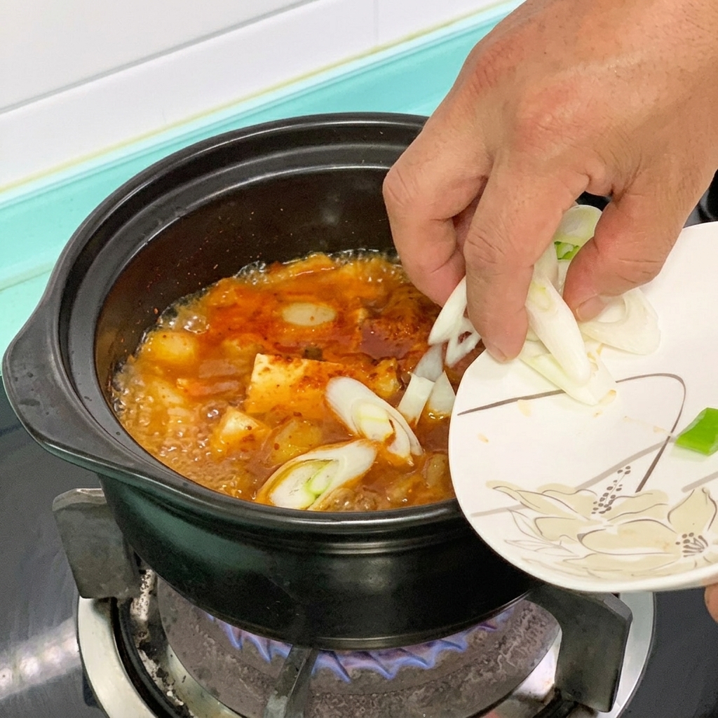 Chile verde y cebolleta añadidos a la olla de estofado de tofu.