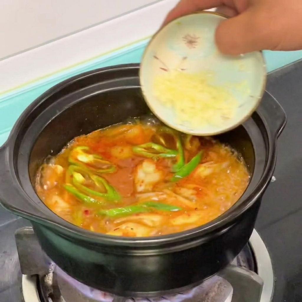 Ajo picado añadido a la olla de estofado de tofu coreano.