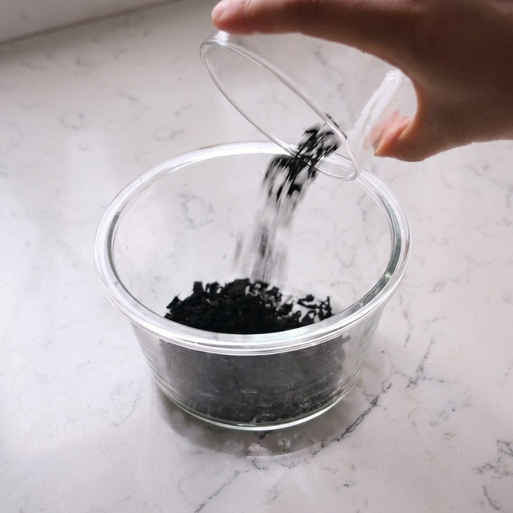 Alga wakame seca remojándose en un bol de cristal con agua.