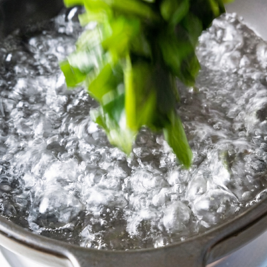 Cubos de tofu y wakame siendo añadidos a una olla de agua hirviendo.