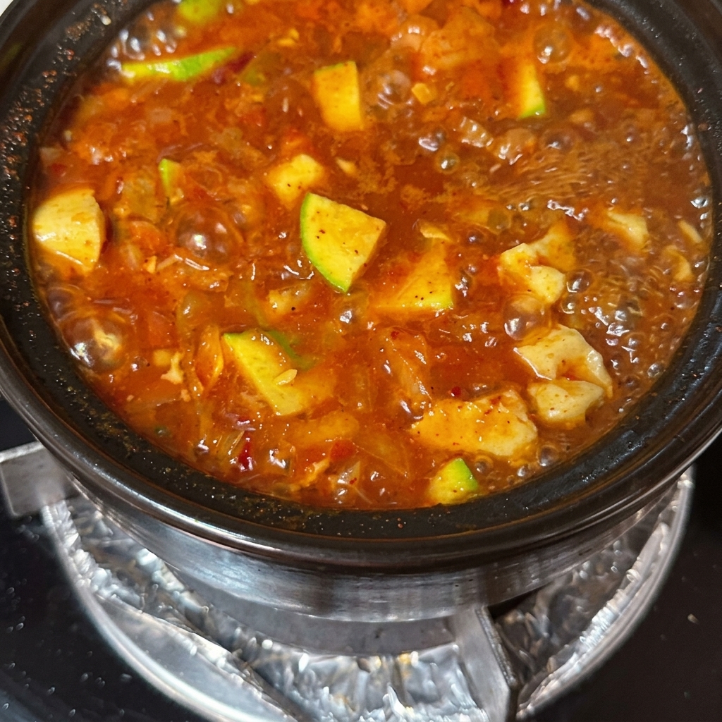 Finas lonchas de ternera y huevos crudos añadiéndose a la sopa hirviendo.