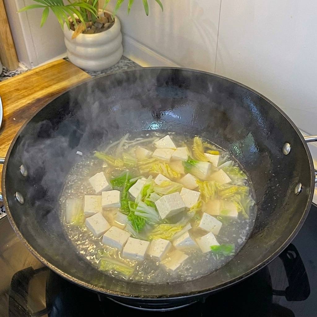 Almejas blancas frescas añadidas a la sopa hirviendo con tofu y huevo.