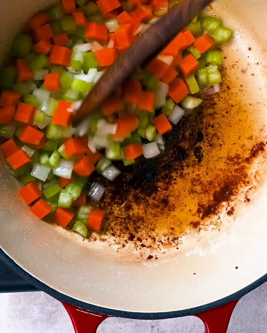 Cebollas, apio y zanahorias sofriéndose en la olla con la grasa del tocino.