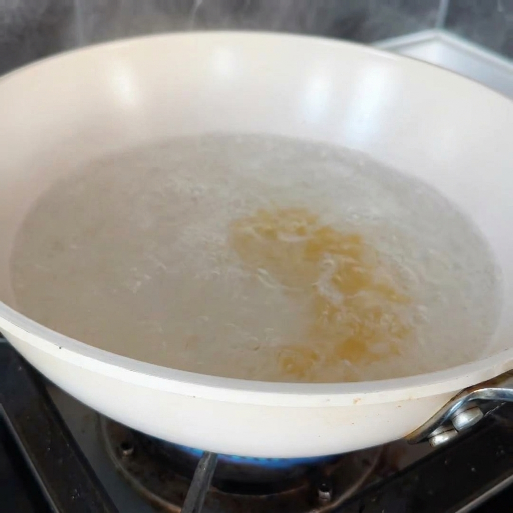 Pasta fusilli hirviendo en una olla grande con agua en la estufa.