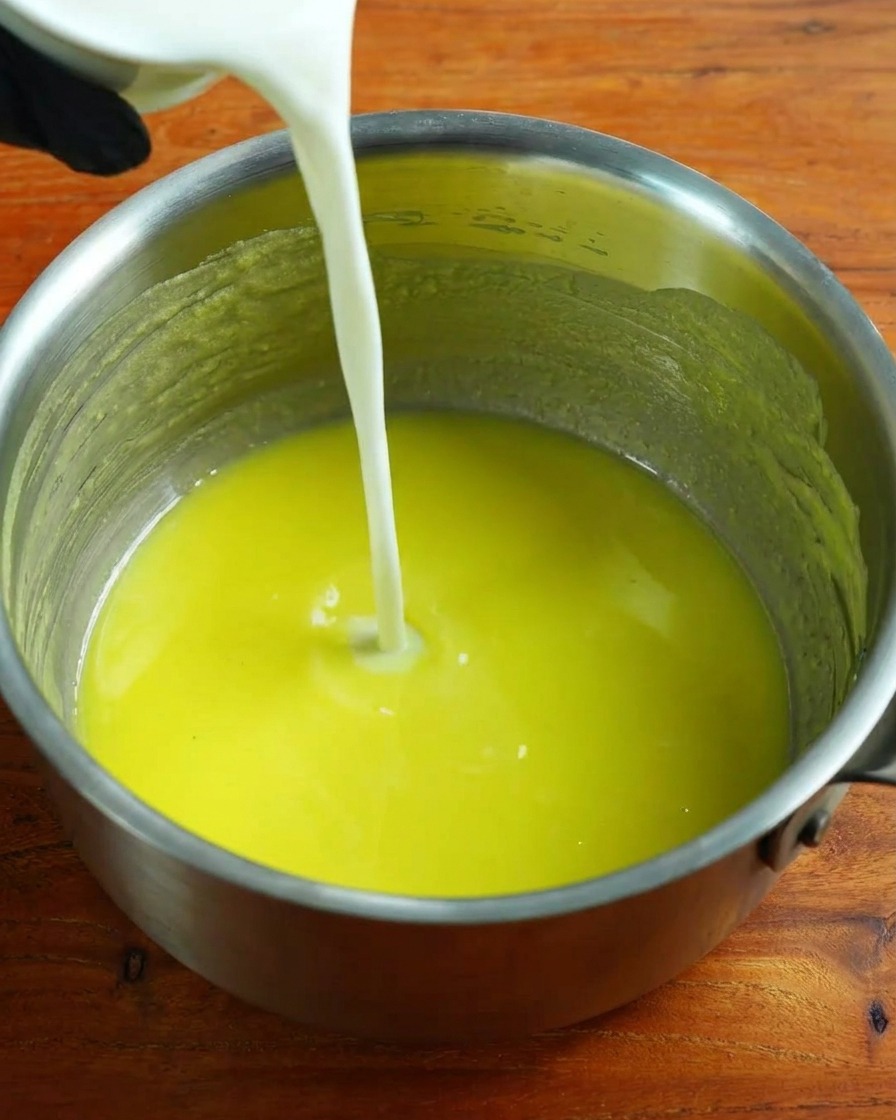 Leche tibia siendo vertida en la base de roux mientras se bate.