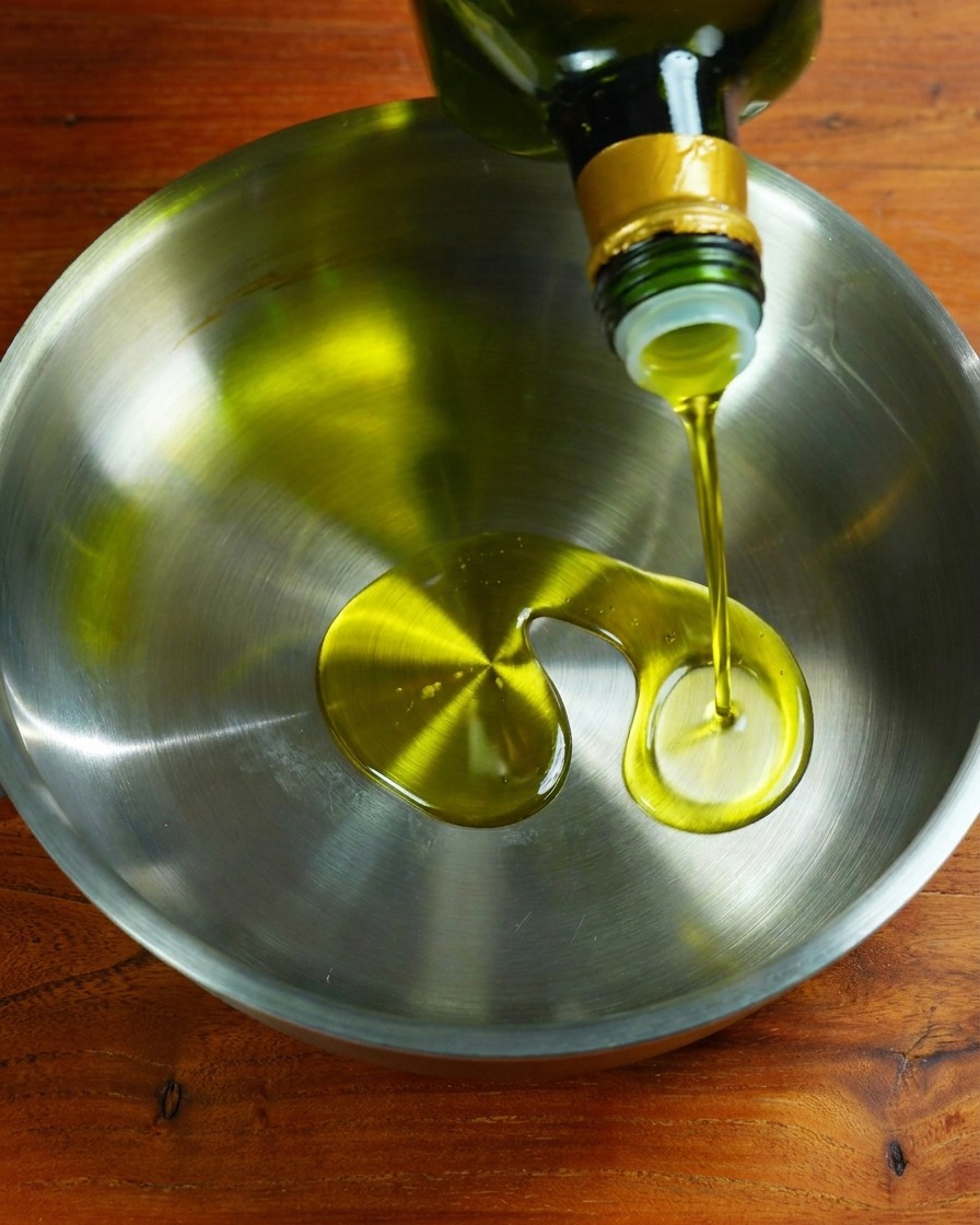 Ajo y cebolla friéndose en aceite en una sartén.