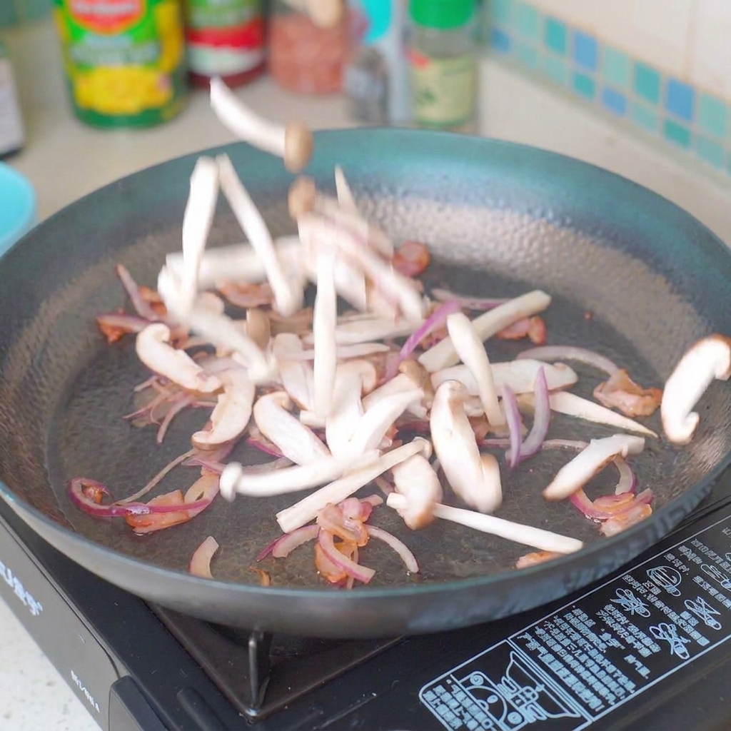 Champiñones y cebollas en rodajas salteándose en la sartén con tocino.